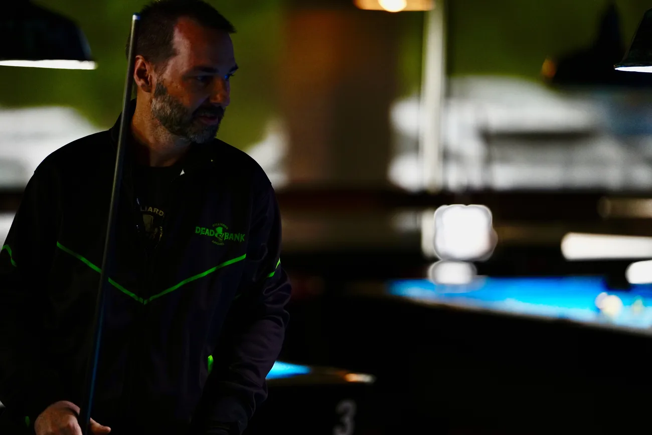 Player wearing the Dead Bank performance jacket in a dark pool hall